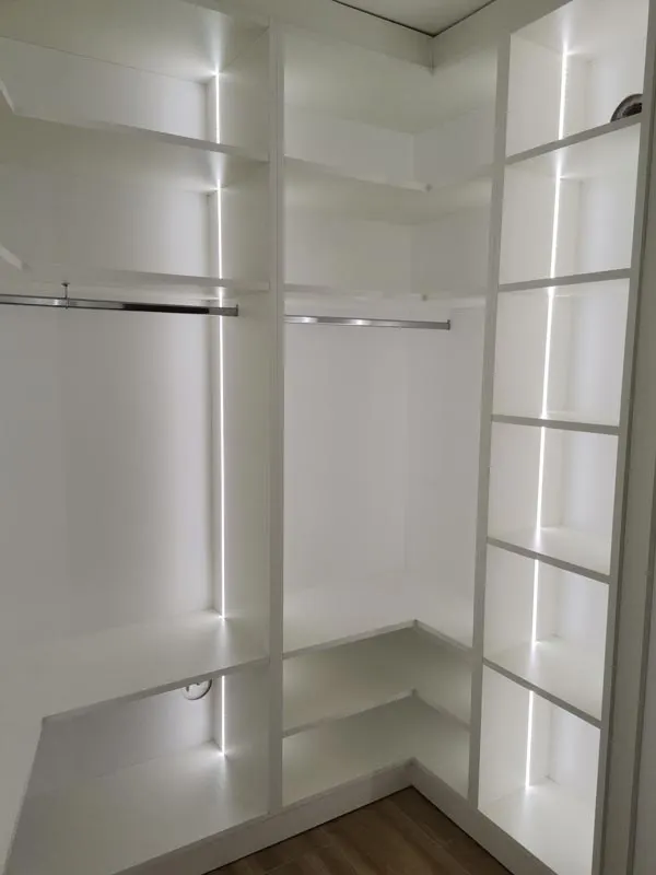 Белая угловая гардеробная со штангами для одежды и LED-подсветкой